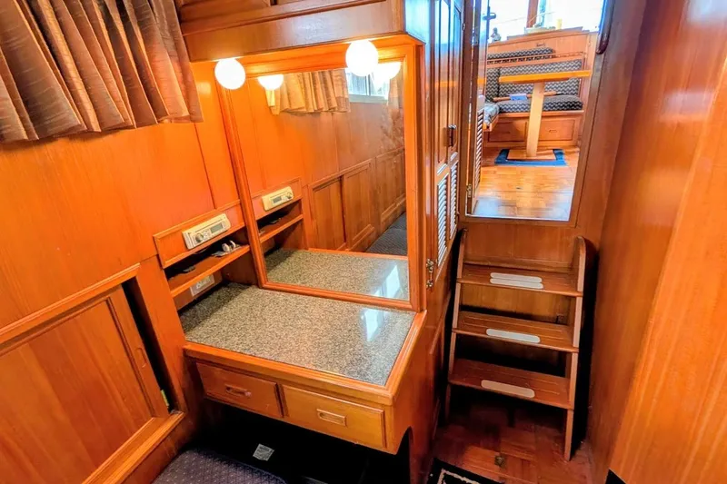 Positive Space Yacht Photos Pics 1987 DeFever Trawler interior with wooden cabinetry, mirror, and stairs leading to dining area.