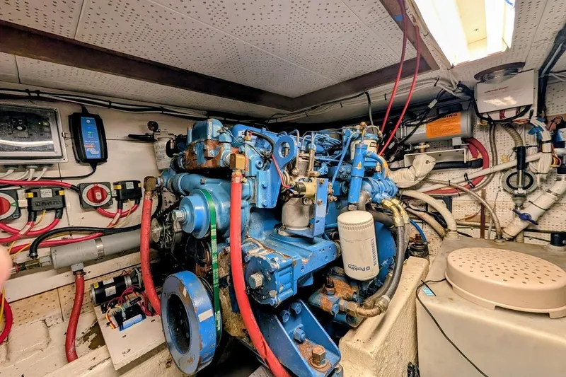 Positive Space Yacht Photos Pics Engine room of a 1987 DeFever Trawler with blue machinery and wiring.
