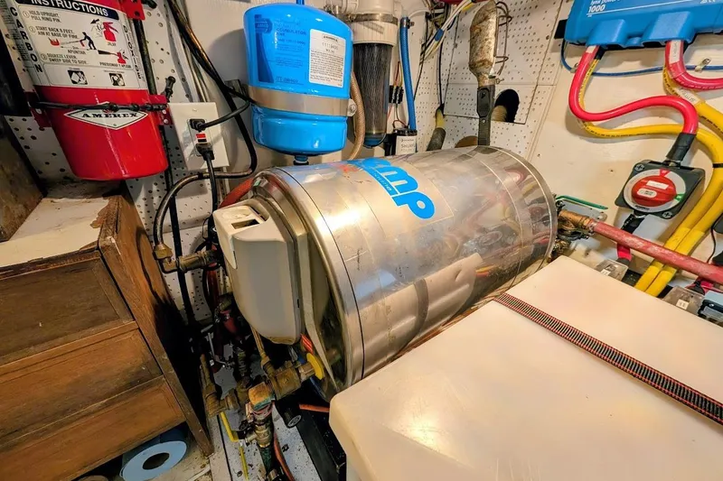 Positive Space Yacht Photos Pics Engine room of a 1987 DeFever Trawler with equipment and fire extinguisher.