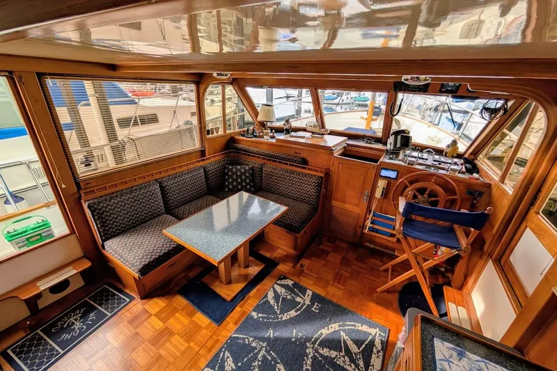 Positive Space Yacht Photos Pics 1987 DeFever Trawler interior with wooden helm, dining area, and nautical decor.