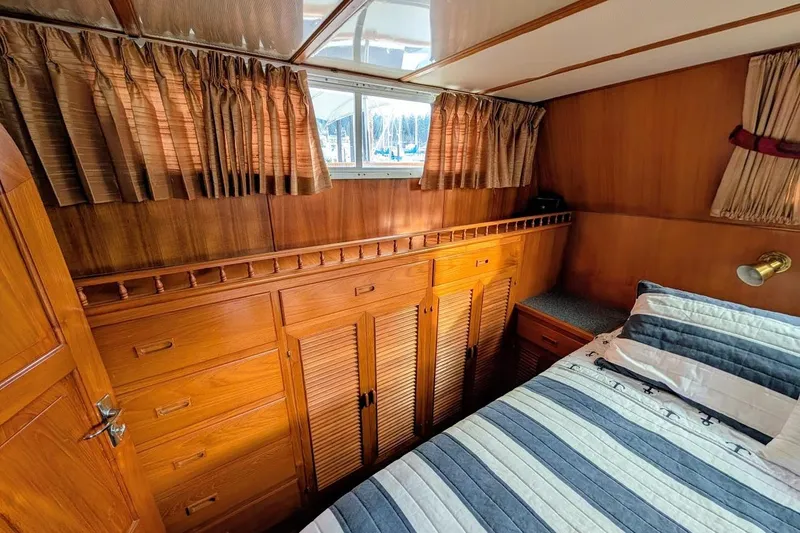 Positive Space Yacht Photos Pics 1987 DeFever Trawler cabin interior with wood paneling, bed, and storage cabinets.