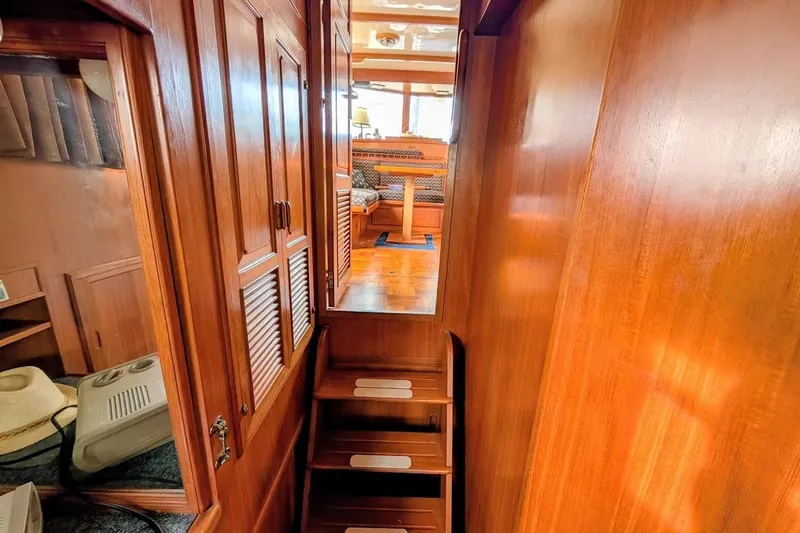 Positive Space Yacht Photos Pics 1987 DeFever Trawler interior with wooden stairs and cabinetry, leading to a cozy seating area.