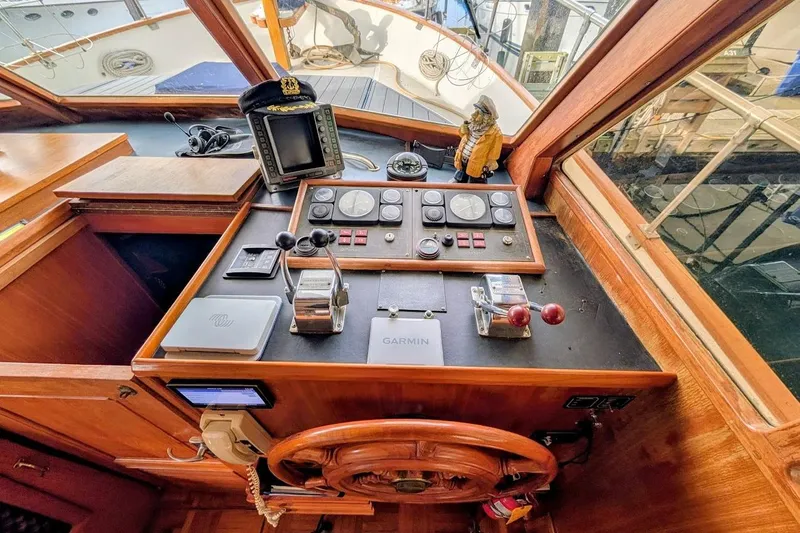 Positive Space Yacht Photos Pics 1987 DeFever Trawler helm with navigation equipment and wooden steering wheel.