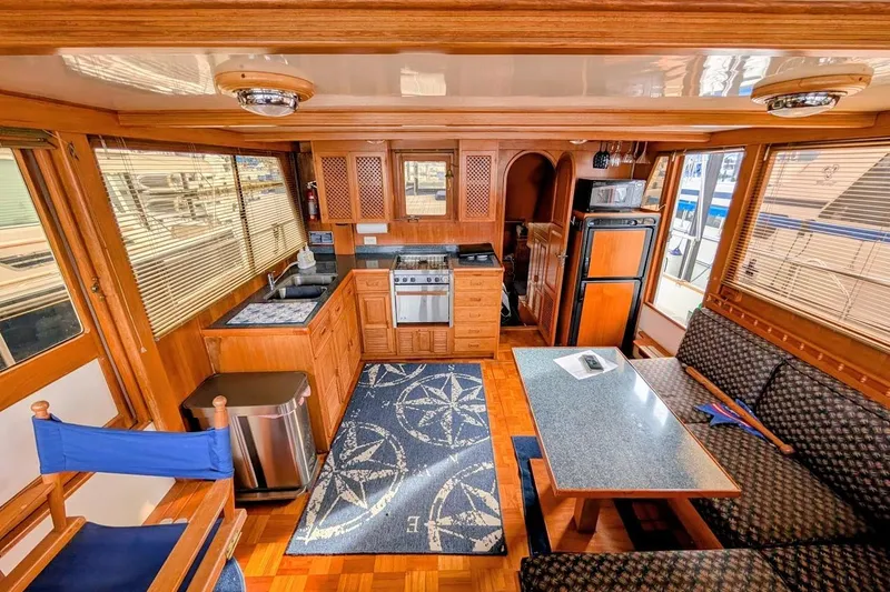 Positive Space Yacht Photos Pics Interior of 1987 DeFever Trawler with kitchen, dining area, and nautical decor.