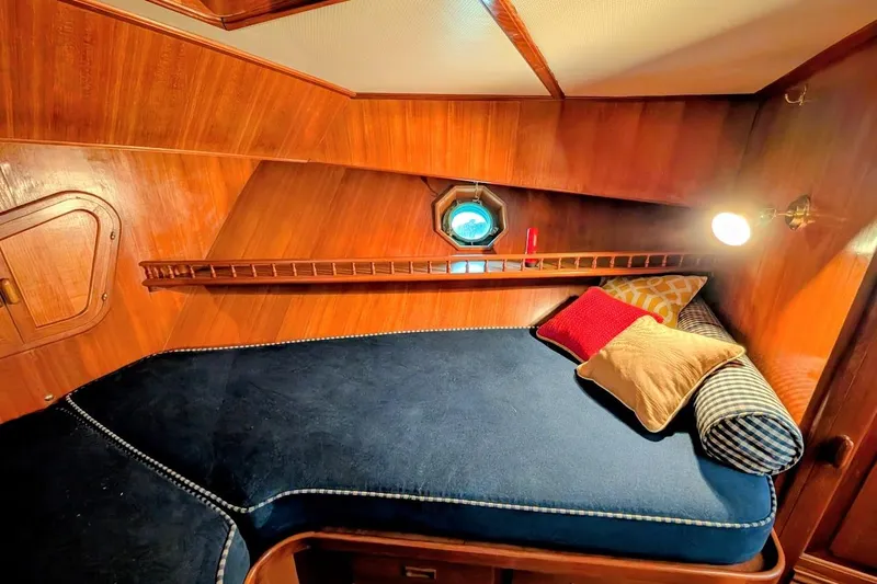 Positive Space Yacht Photos Pics Cozy cabin interior of 1987 DeFever Trawler with wooden walls and plush bedding.