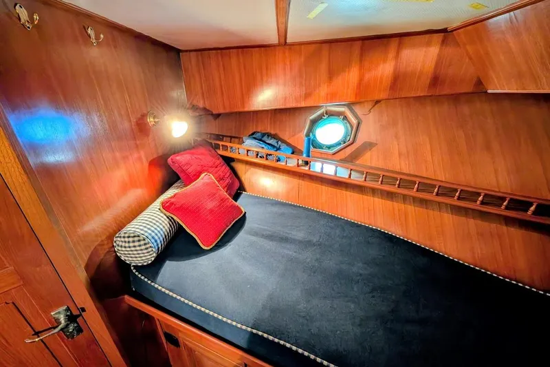 Positive Space Yacht Photos Pics 1987 DeFever Trawler cabin with cozy bed, wooden interior, and nautical decor.