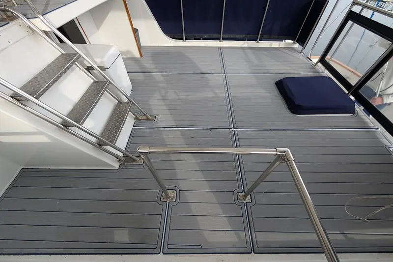 Positive Space Yacht Photos Pics 1987 DeFever Trawler deck with metal stairs and cushioned seating area.