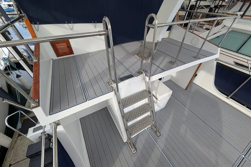 Positive Space Yacht Photos Pics 1987 DeFever Trawler deck with metal ladder and railing, featuring gray flooring.