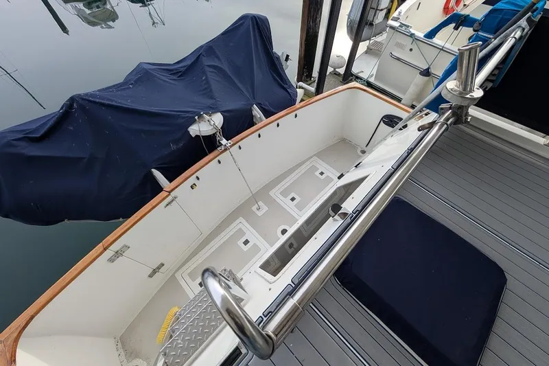 Positive Space Yacht Photos Pics 1987 DeFever Trawler deck with covered equipment and stainless steel railings.