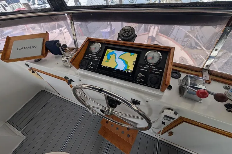 Positive Space Yacht Photos Pics 1987 DeFever Trawler helm with Garmin navigation, steering wheel, and control panel.