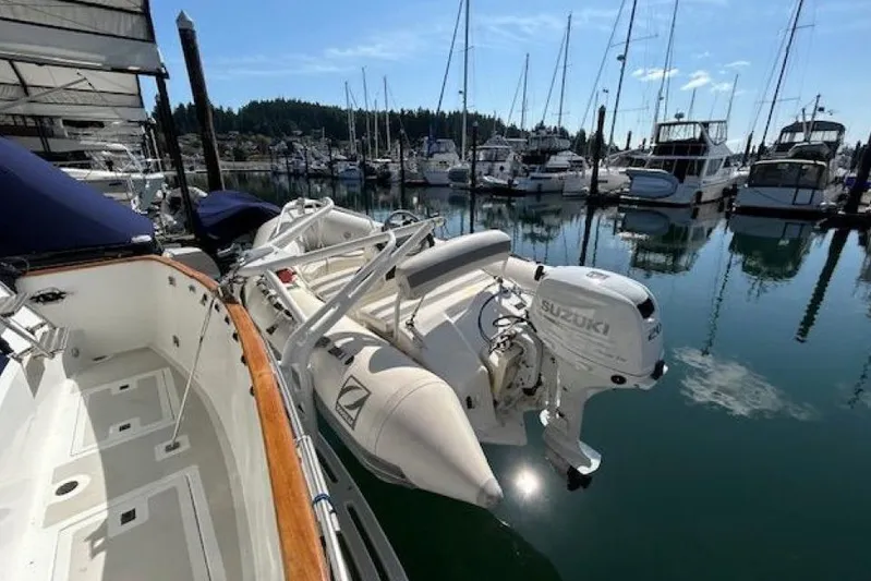 Positive Space Yacht Photos Pics 1987 DeFever Trawler with Suzuki outboard motor docked in a marina.