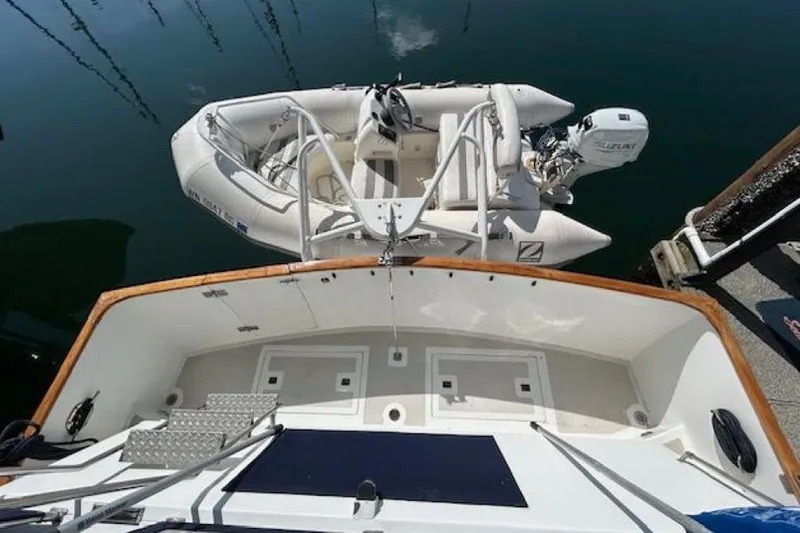 Positive Space Yacht Photos Pics 1987 DeFever Trawler with dinghy and Suzuki outboard motor at dock.