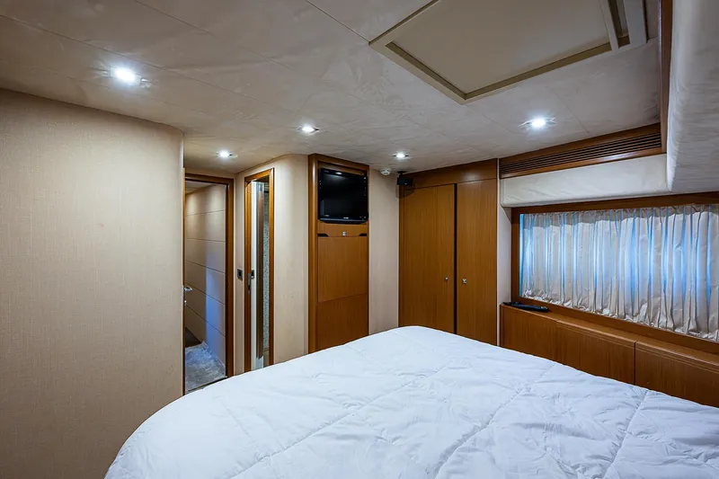 Twe11ve Yacht Photos Pics Luxurious bedroom interior of 2009 Ferretti Yachts 780 MY with wood paneling and cozy lighting.