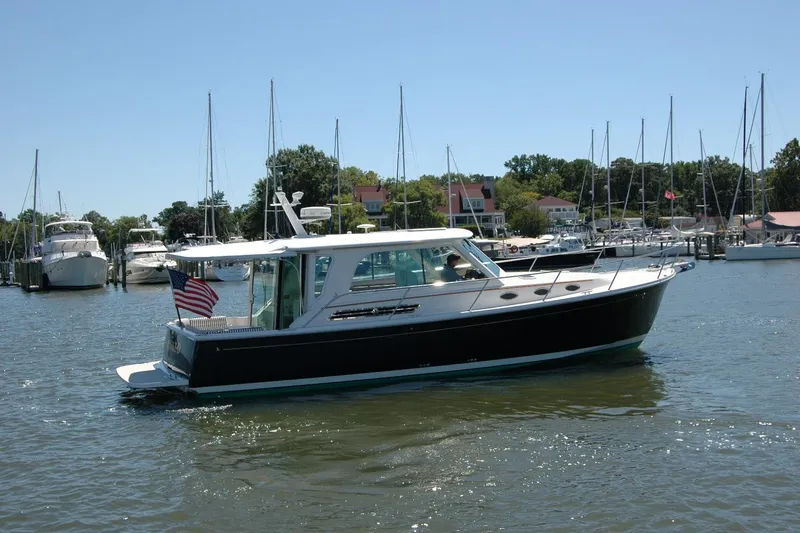 Double D Yacht Photos Pics 2014 Back Cove 37 boat cruising in a marina with sailboats in the background.