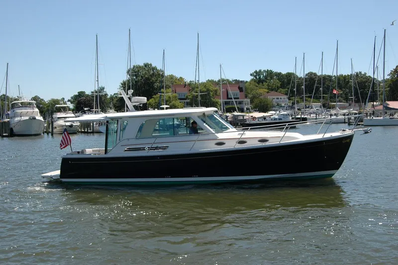Double D Yacht Photos Pics 2014 Back Cove 37 yacht cruising in a marina with sailboats in the background.