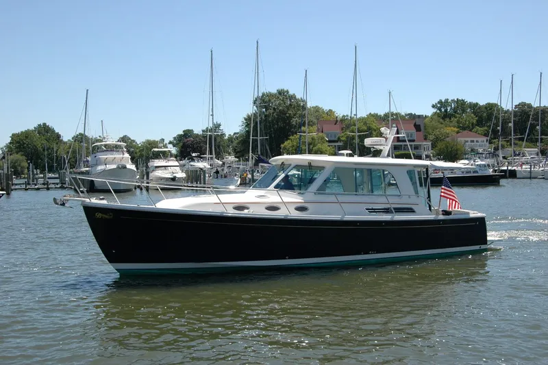 Double D Yacht Photos Pics 2014 Back Cove 37 yacht cruising in a marina with sailboats and trees in the background.