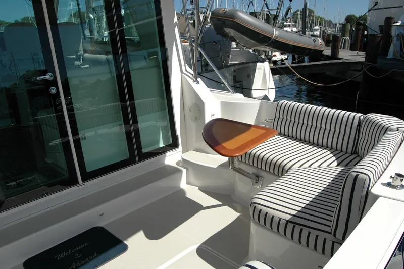 Double D Yacht Photos Pics 2014 Back Cove 37 yacht with striped seating and wooden table on deck.