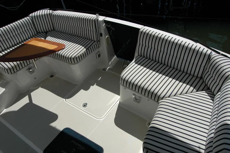 Double D Yacht Photos Pics 2014 Back Cove 37 boat interior with striped seating and wooden table.