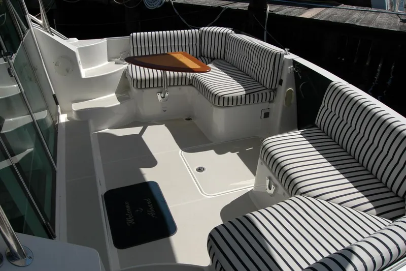 Double D Yacht Photos Pics 2014 Back Cove 37 boat interior with striped seating and a small wooden table.
