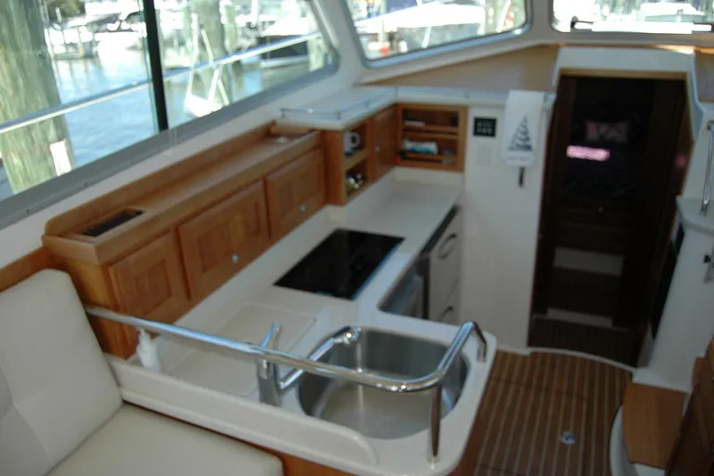 Double D Yacht Photos Pics Interior of 2014 Back Cove 37 yacht, featuring a compact kitchen with wooden cabinetry.