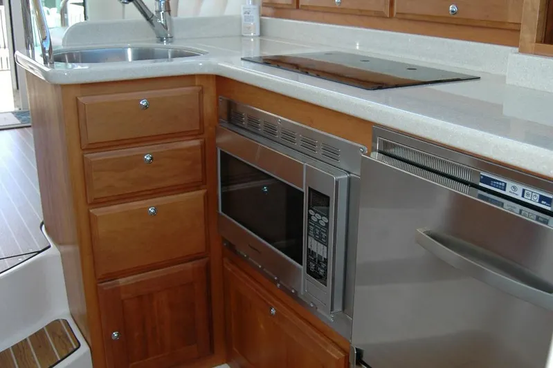 Double D Yacht Photos Pics 2014 Back Cove 37 yacht kitchen with wooden cabinets, microwave, and stainless steel appliances.
