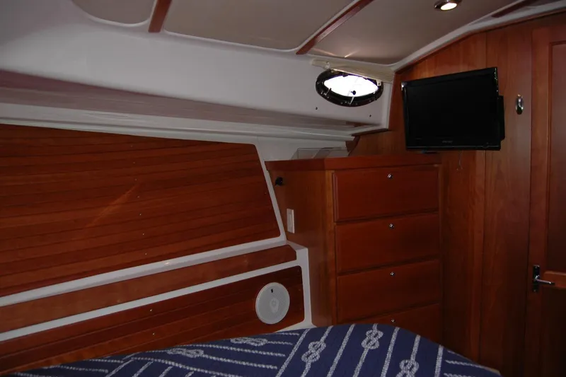 Double D Yacht Photos Pics 2014 Back Cove 37 interior cabin with wood paneling, drawers, and a mounted TV.