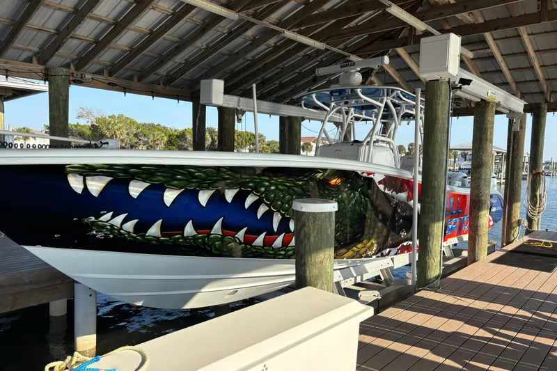  Yacht Photos Pics 2024 Yellowfin 36 Offshore boat with striking alligator-themed hull art in a marina.