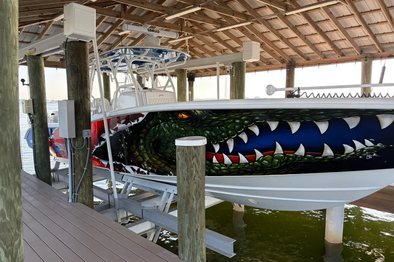  Yacht Photos Pics 2024 Yellowfin 36 Offshore boat with striking crocodile-themed hull artwork in a covered dock.