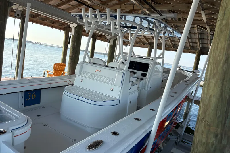  Yacht Photos Pics 2024 Yellowfin 36 Offshore boat docked under a wooden shelter by the water.