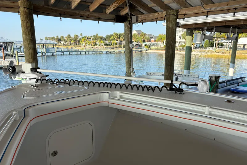  Yacht Photos Pics 2024 Yellowfin 36 Offshore boat docked under a wooden canopy by the waterfront.