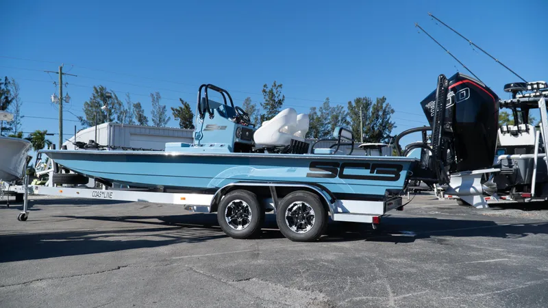  Yacht Photos Pics 2025 SCB S22 boat on trailer, blue hull, dual axles, parked outdoors.