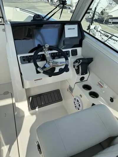  Yacht Photos Pics 2024 Sailfish 276 DC boat cockpit with steering wheel and control panel.