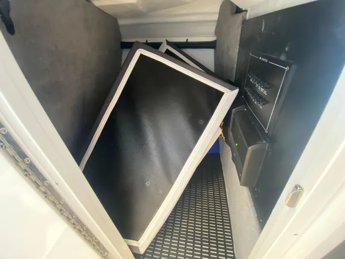  Yacht Photos Pics Storage compartment in a 2023 Monterey 298 SUPER SPORT BR boat, featuring black panels.