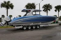 2018 Mystic Powerboats M4200 on trailer, blue hull, parked near palm trees.