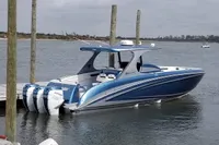 2018 Mystic Powerboats M4200, blue and white, docked with triple outboard engines.