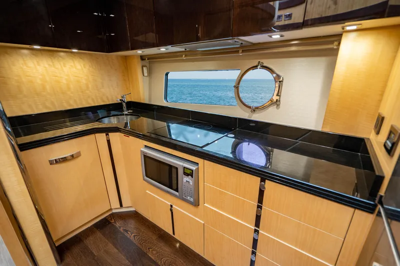 Yolo Yacht Photos Pics 2014 Sunseeker Predator yacht kitchen with black countertops and ocean view.