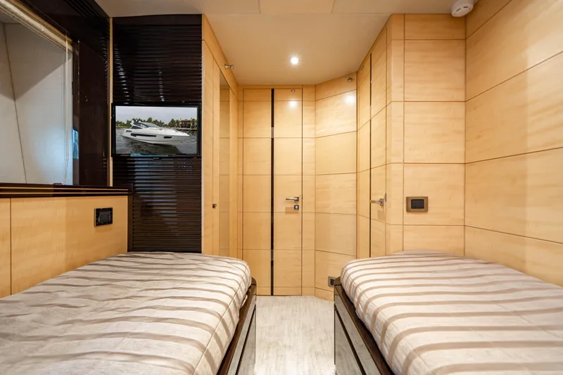 Yolo Yacht Photos Pics 2014 Sunseeker Predator twin cabin with modern wood paneling and striped bedding.