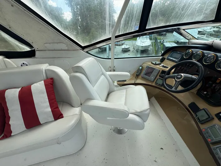 Beautiful Crazy Yacht Photos Pics Pilothouse interior of 2003 Carver 570 Voyager with white seating and navigation controls.