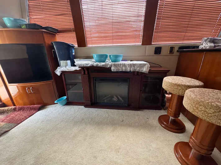 Beautiful Crazy Yacht Photos Pics Interior of 2003 Carver 570 Voyager Pilothouse with fireplace, stools, and wooden cabinetry.