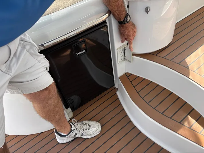 Cookin' Yacht Photos Pics Man pointing at outlet on 2008 Formula 37 PC boat deck with wood finish.