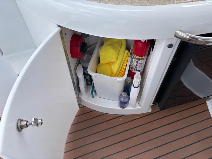 Cookin' Yacht Photos Pics Open cabinet on 2008 Formula 37 PC boat with cleaning supplies and fire extinguisher.