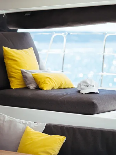Duolife Yacht Photos Pics Luxurious interior of 2019 Lagoon 620 Essence yacht with yellow and gray cushions.