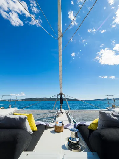 Duolife Yacht Photos Pics 2019 Lagoon 620 Essence yacht deck with cushions, under a clear blue sky.