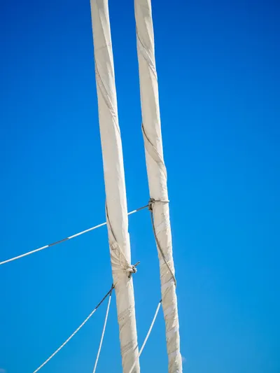 Duolife Yacht Photos Pics Sails of a 2019 Lagoon 620 Essence against a clear blue sky.