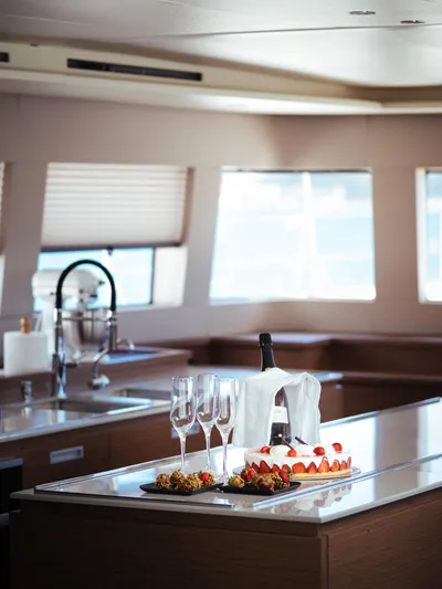 Duolife Yacht Photos Pics Luxurious interior of 2019 Lagoon 620 Essence yacht with wine, glasses, and dessert.