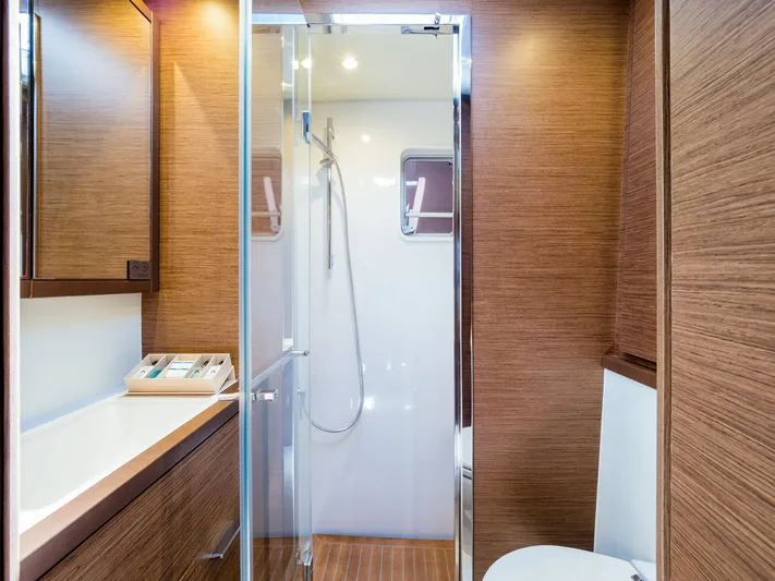 Duolife Yacht Photos Pics Luxurious bathroom interior of 2019 Lagoon 620 Essence yacht with wood paneling and modern fixtures.