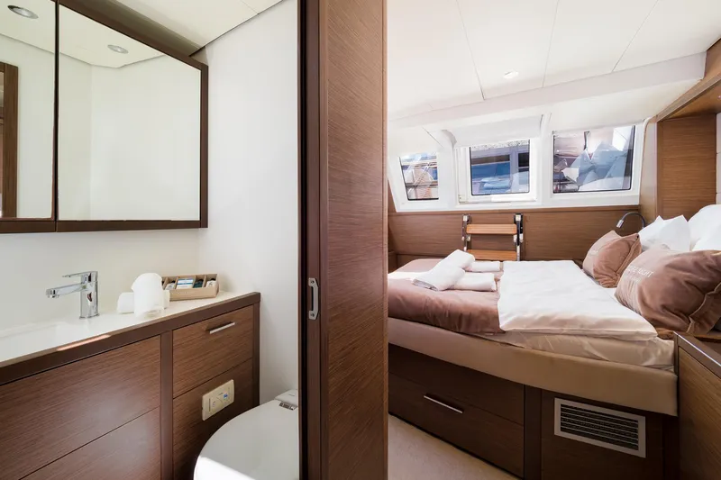 Duolife Yacht Photos Pics Luxurious cabin interior of 2019 Lagoon 620 Essence yacht with modern bathroom and cozy bed.