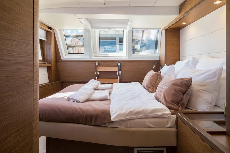 Duolife Yacht Photos Pics Luxurious bedroom interior of 2019 Lagoon 620 Essence yacht with elegant wood finish and natural light.