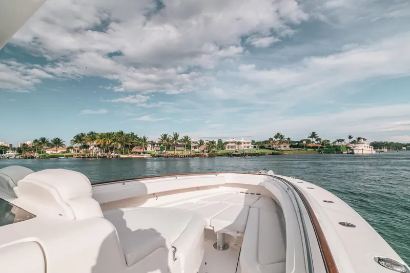  Yacht Photos Pics 2021 HCB 42 Lujo yacht cruising near a scenic coastal area under a partly cloudy sky.