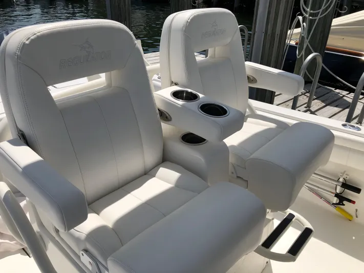  Yacht Photos Pics 2018 Regulator 28 Center Console boat seats with cup holders, docked by water.